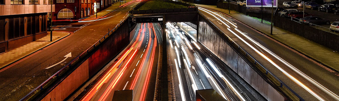 Testimonials: A busy street at night capturing the red lights of the traffic.